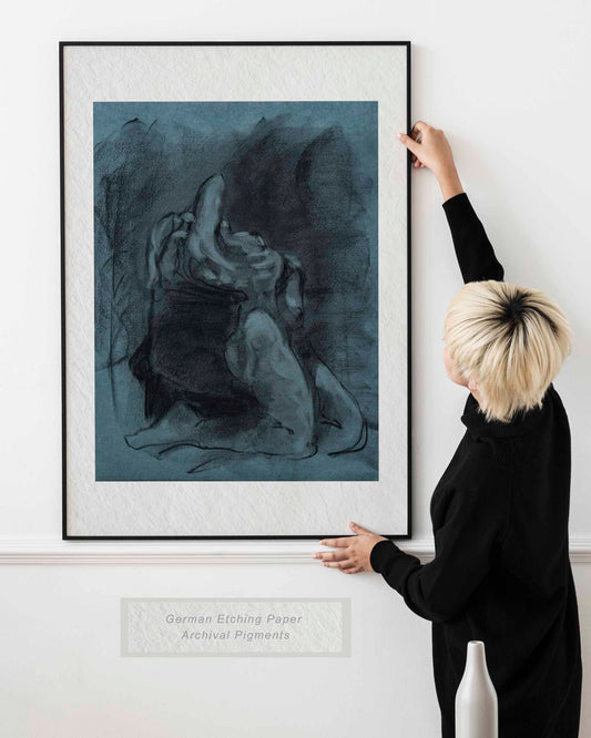 Woman holding framed Returned from Shadow fine art print by Bogdan Jensen on a wall, showing the dark blue charcoal figure drawing in a bright interior