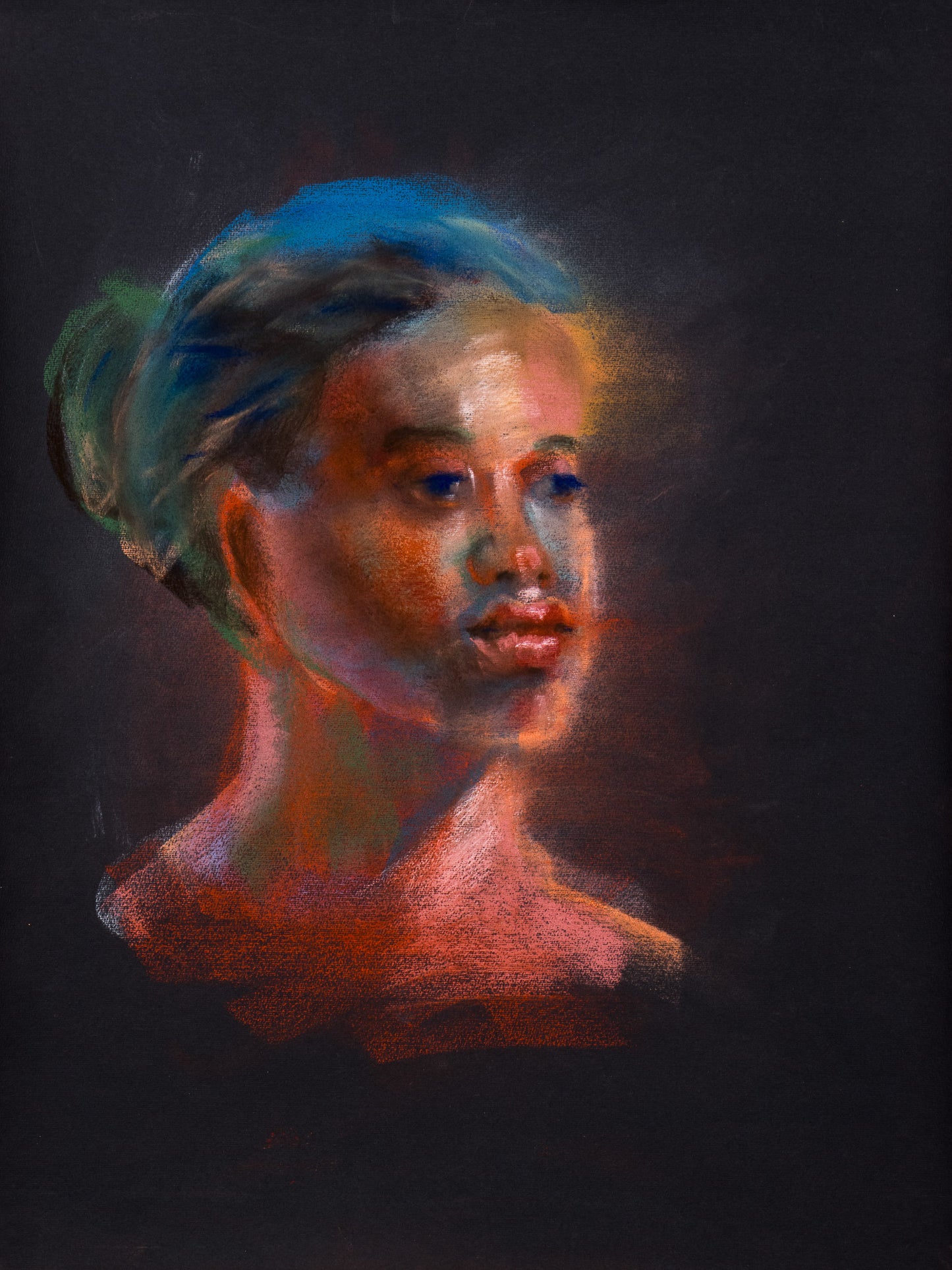 Original pastel drawing of a portrait emerging from black paper in red, blue, and green tones, exploring warmth and luminous presence.