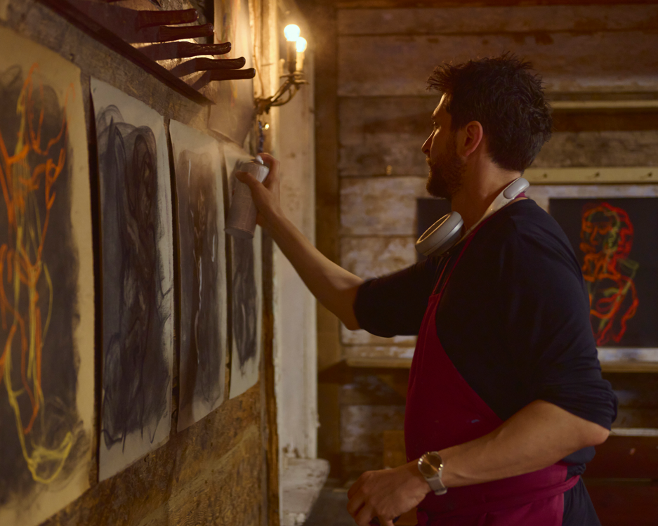 Artist Bogdan Jensen hanging the exhibtiion "Becoming an Image" in Monbijou Theater Berlin, of his soft pastel drawings made live during the theater performance from the life actor on stage. 