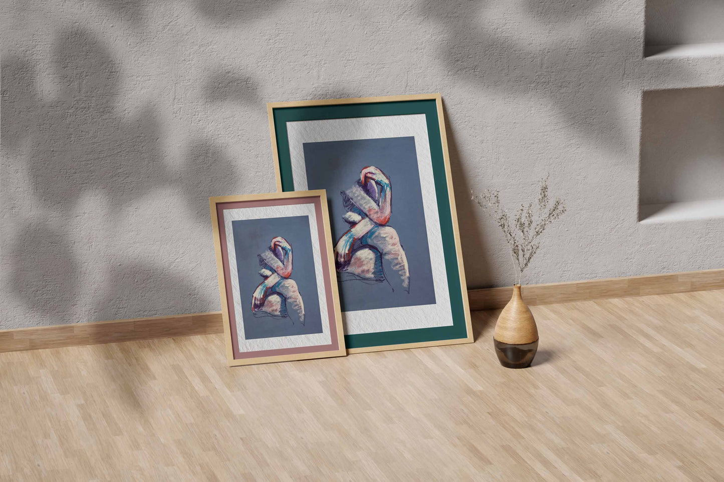A Gentle Touch fine art print by Bogdan Jensen shown leaning in a floor frame, with the seated pastel figure beside a smaller framed artwork