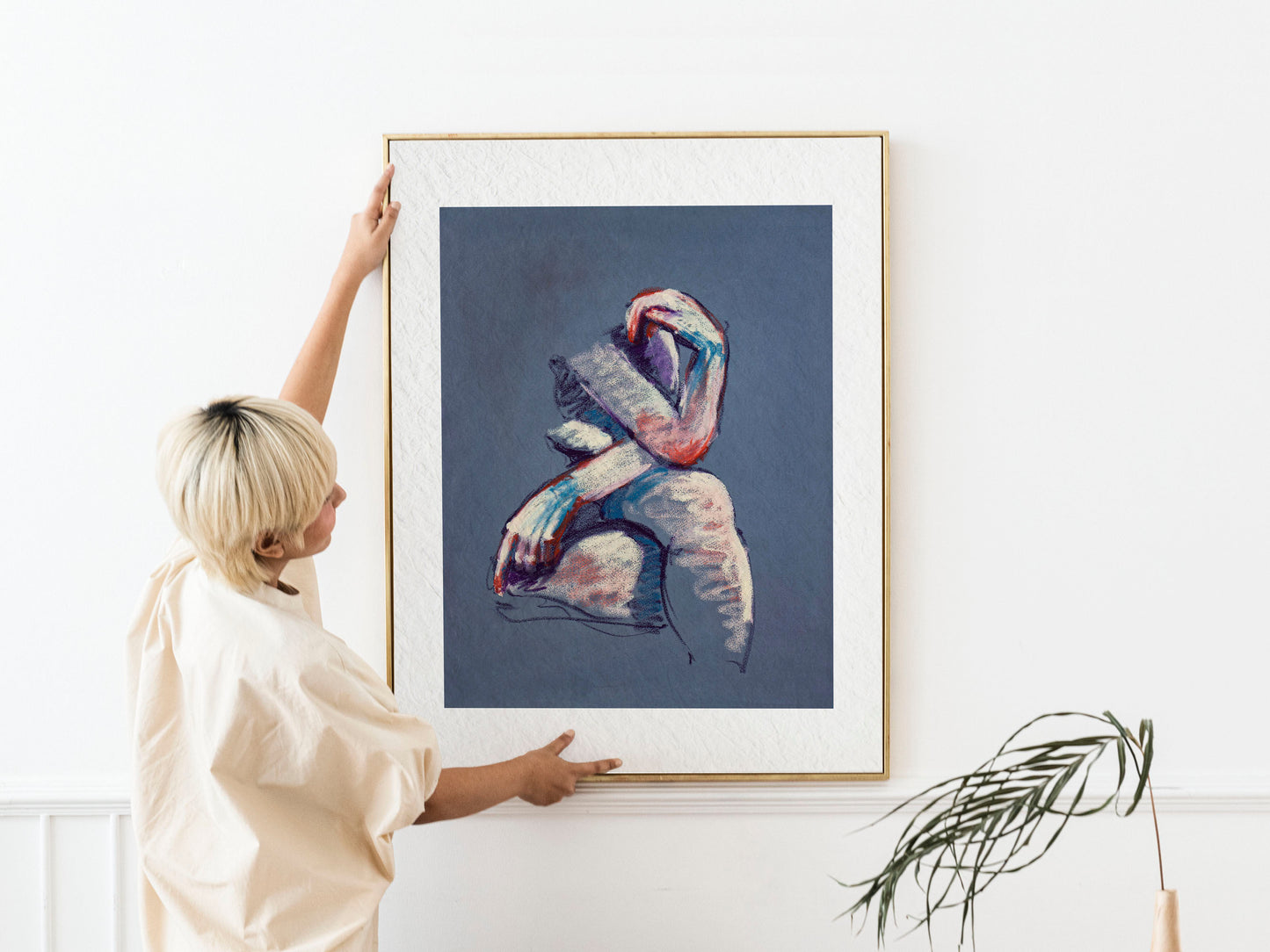 Framed A Gentle Touch fine art print by Bogdan Jensen shown at human scale, featuring a seated pastel figure with pale tones and cool blue shadows
