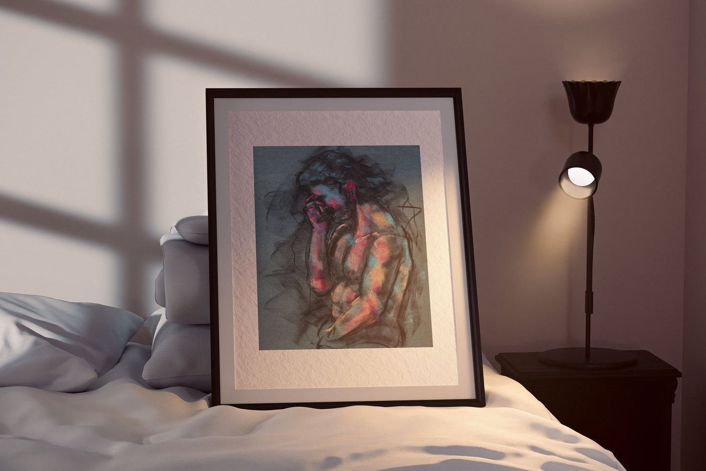A Quiet Ache fine art print by Bogdan Jensen shown framed beside a bed, with the seated figure rendered in charcoal with blue and rose highlights