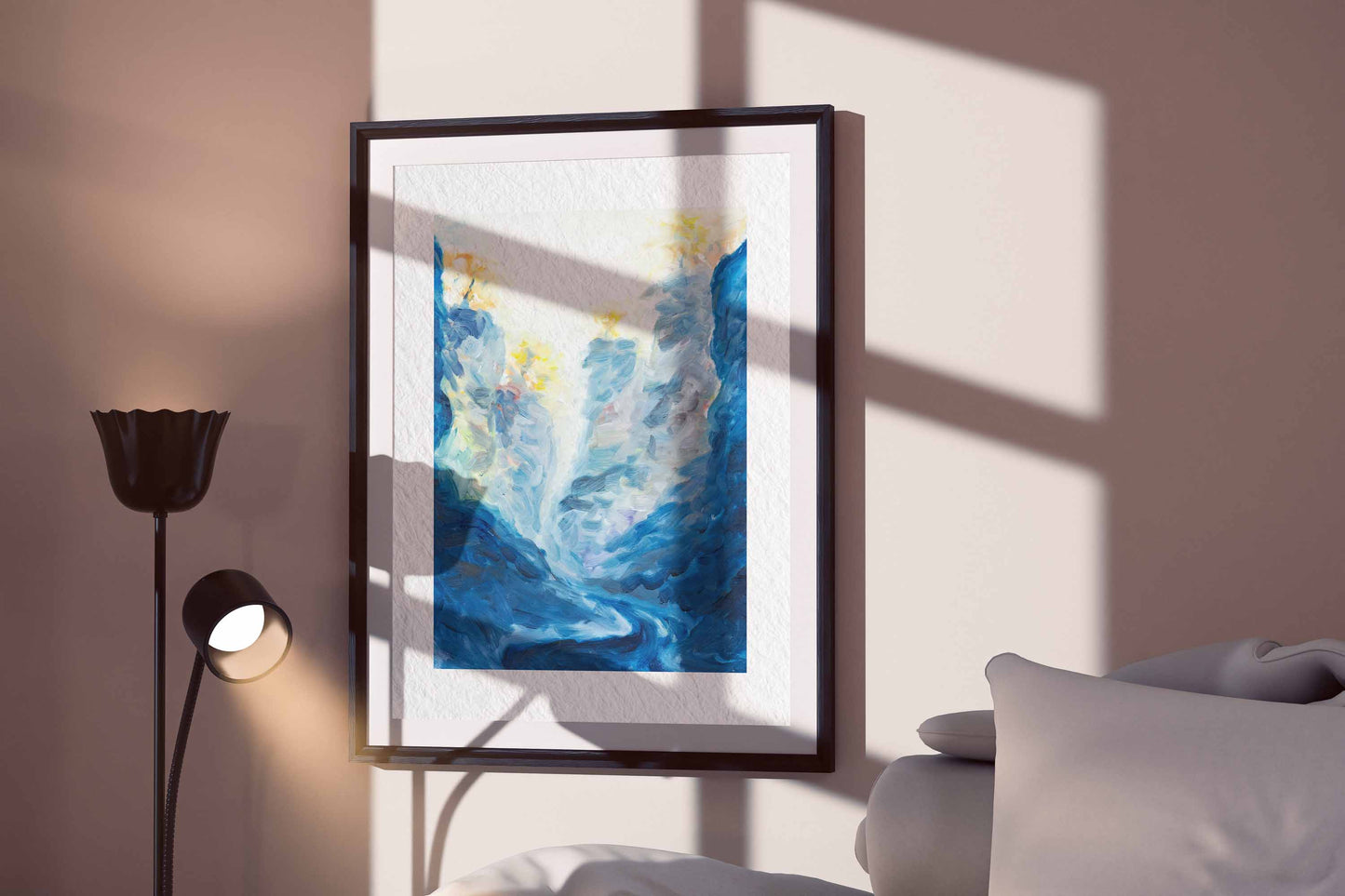 Blue Passage fine art print by Bogdan Jensen shown framed beside a bed, with deep blue brushwork and pale light in a quiet interior