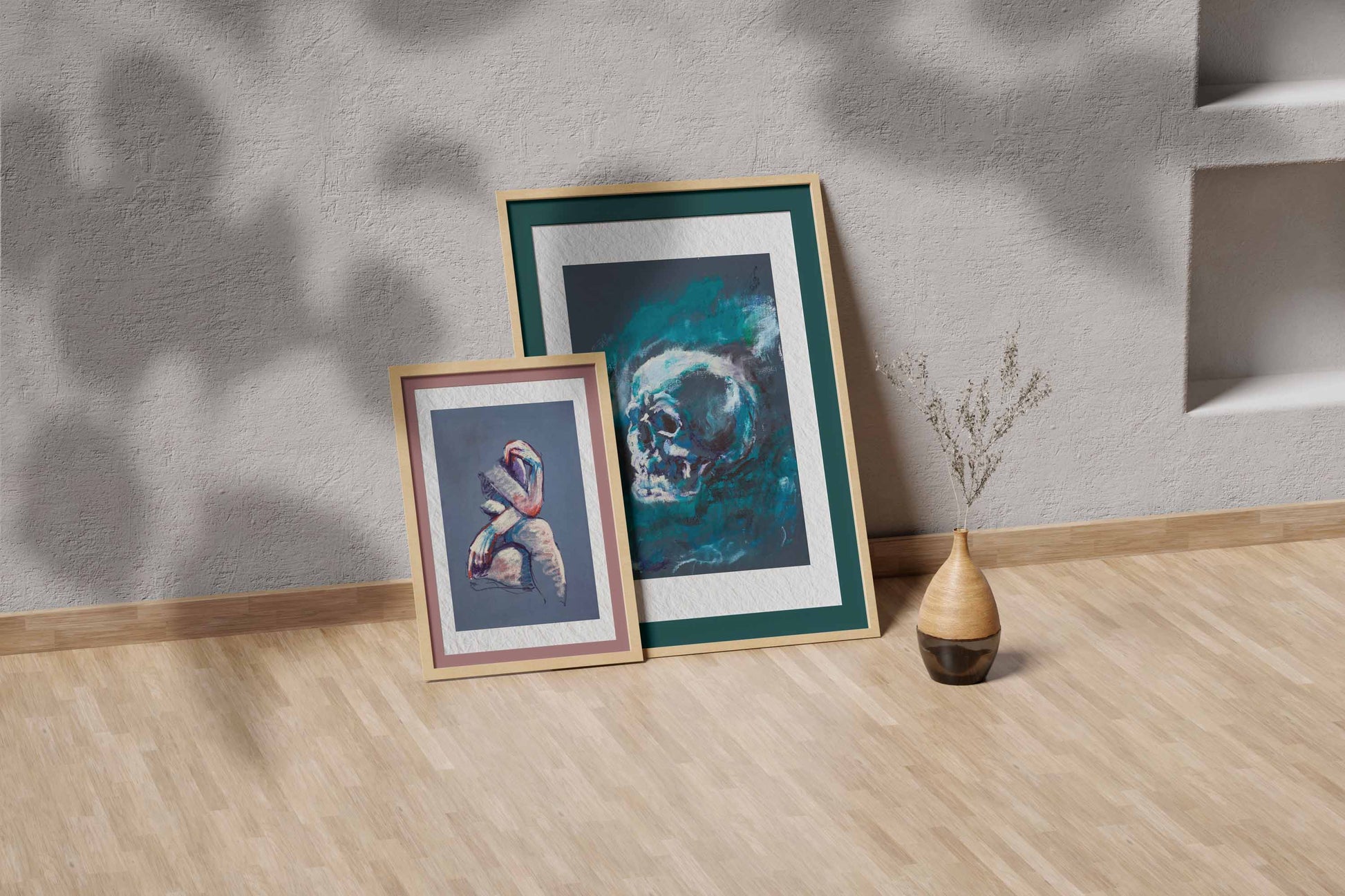 Blue Remains fine art print by Bogdan Jensen shown leaning in a floor frame, with the blue-toned skull study beside a smaller framed artwork