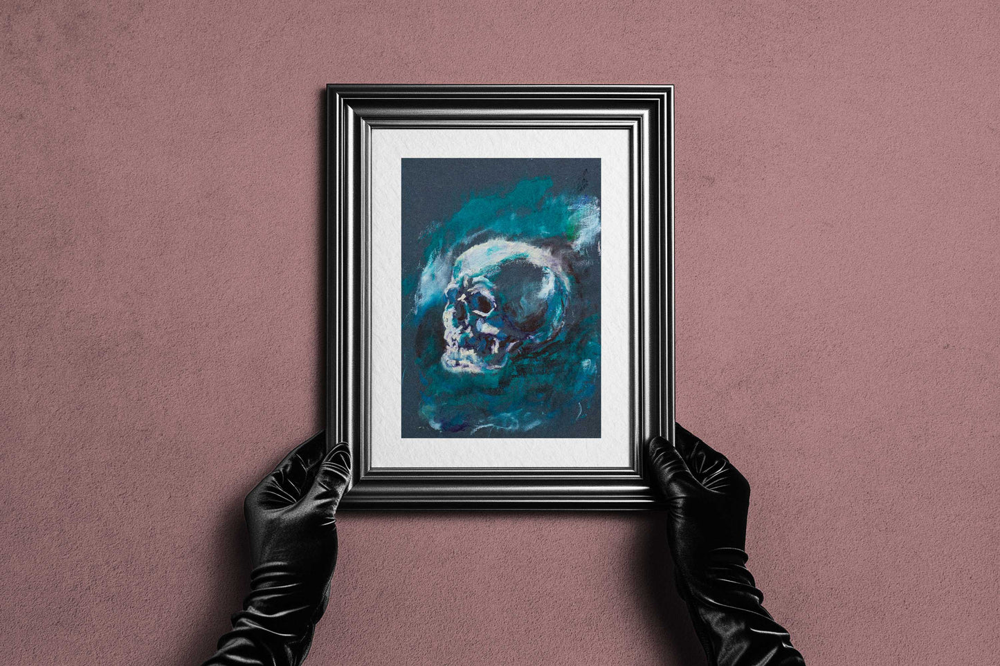 Framed Blue Remains fine art print by Bogdan Jensen held by hands, showing the blue-toned skull study in a dark frame