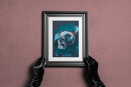 Framed Blue Remains fine art print by Bogdan Jensen held by hands, showing the blue-toned skull study in a dark frame