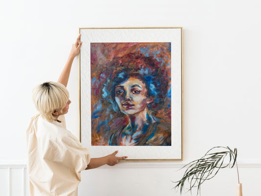 Framed Blue Tempest fine art print by Bogdan Jensen shown at human scale, featuring a vivid soft pastel portrait in blue, rust, and crimson tones