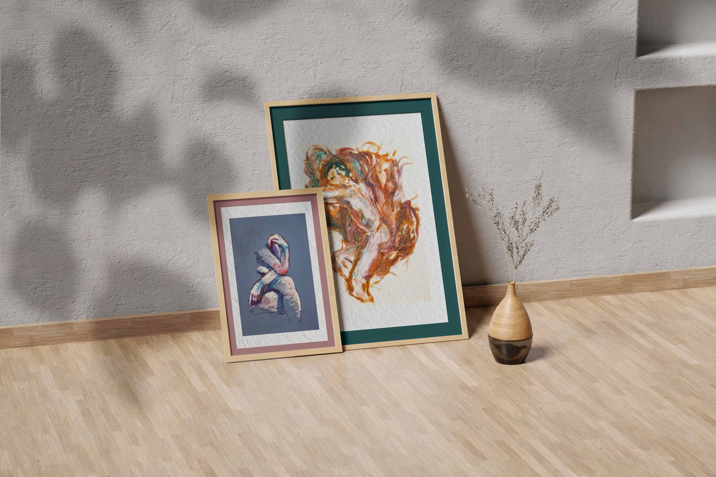 Held by Fire fine art print by Bogdan Jensen shown leaning in a floor frame, with the reclining figure painting beside a smaller framed artwork