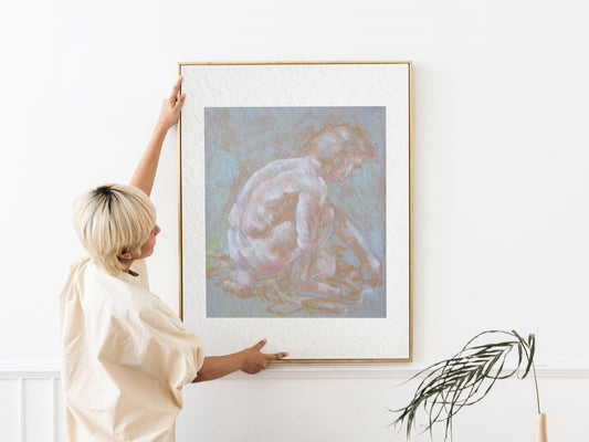 Framed Inner Stillness fine art print by Bogdan Jensen shown at human scale, featuring a pale crouched figure from an original soft pastel life drawing