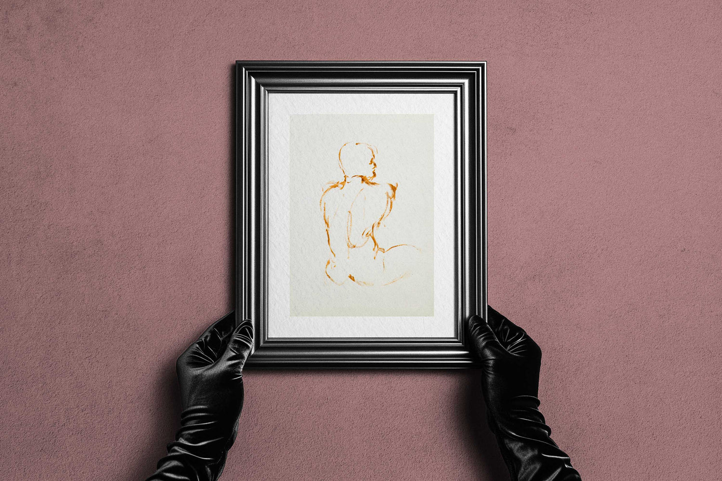 Framed Lost in Line fine art print by Bogdan Jensen held by hands, showing the spare ochre figure drawing in a dark frame