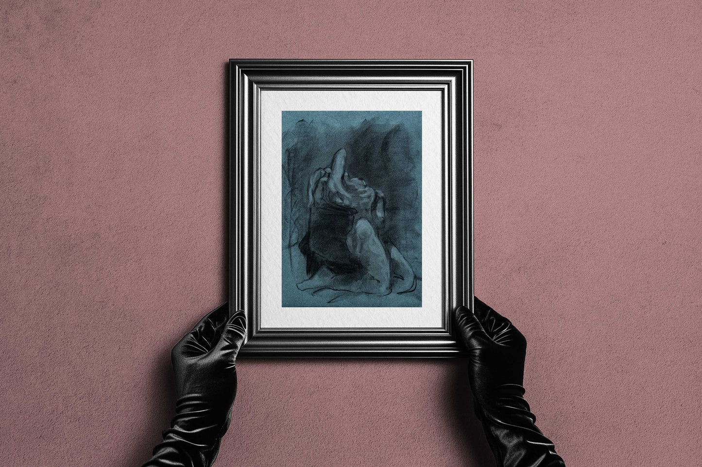 Framed Returned from Shadow fine art print by Bogdan Jensen held by hands, showing the blue-toned charcoal figure drawing in a dark frame