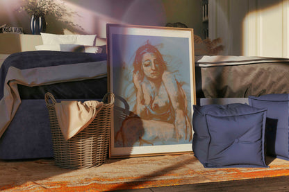 Large Soft Whisper fine art print in a gold frame, leaning in a warm bedroom interior with soft light, blue cushions, and natural textures.
