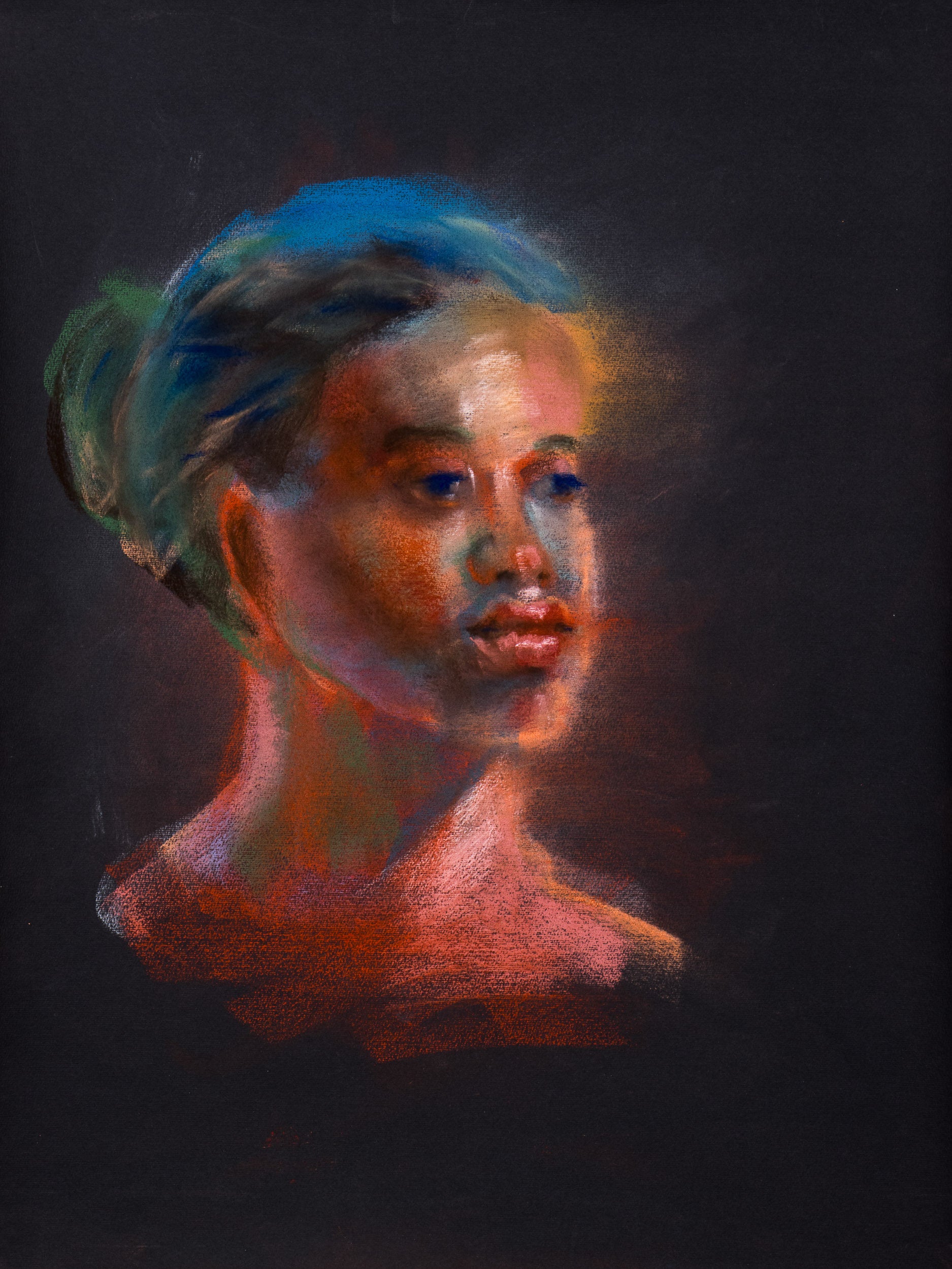 Original pastel drawing of a portrait emerging from black paper in red, blue, and green tones, exploring warmth and luminous presence.