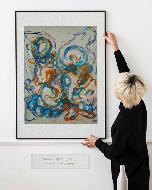 Woman holding framed Together in the Garlands fine art print by Bogdan Jensen on a wall, showing abstract figurative forms in blue, ochre, teal, and violet